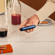 Hand holding a Ploom AURA device with a Navy Blue front panel accessory
