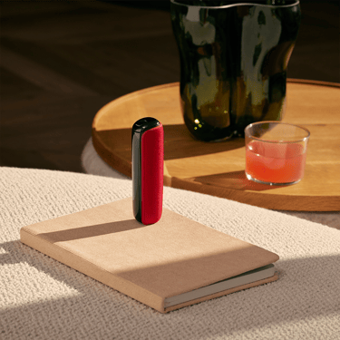 Ploom device with Lava Red Back Cover on book